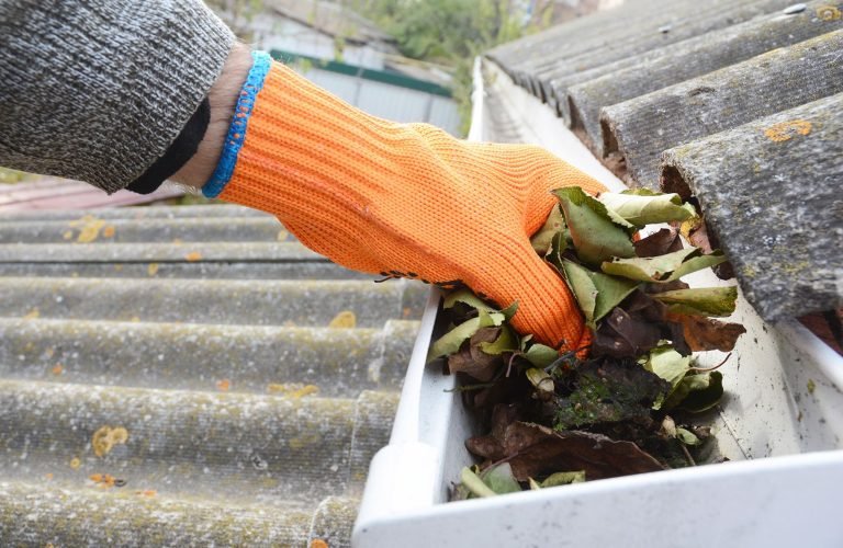 person-cleaning-out-roof-gutter-a7d758c873274953bd00f9dfd35b665d-1